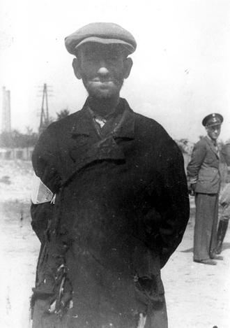 A Jew in Tomaszow Mazowiecki with a Jewish policeman in the bacground